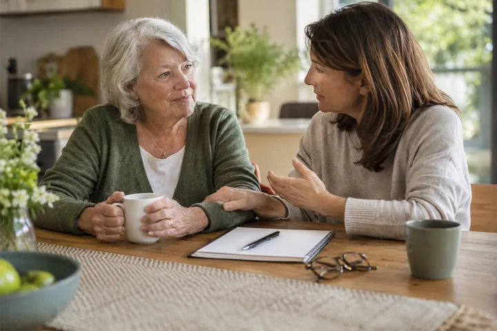 Two adults talking together at a kitchen table