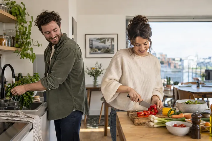 Two adults preparing a meal together at home