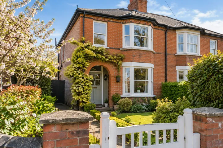 A red-brick house with a small front garden